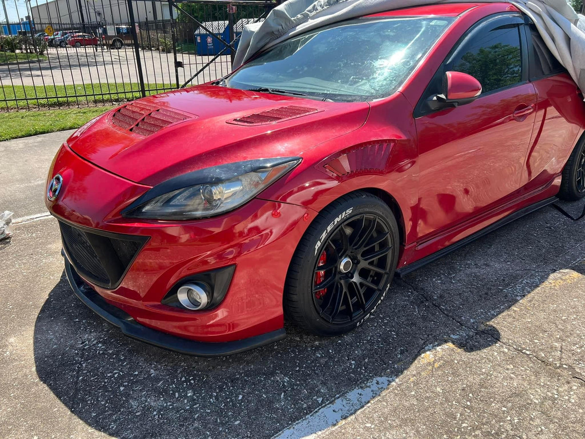 Red bumper latches on a red second-generation Mazdaspeed3 with a vented hood and fenders.