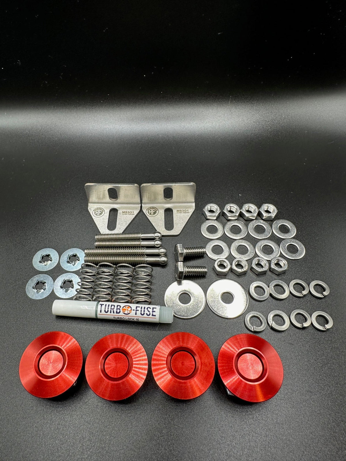 RaiderFab first-generation Mazda3 full bumper kit with four red latches, brackets, threadlocker and hardware.