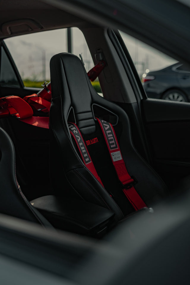 Black Braum bucket seat with a red harness in the Mazdaspeed3 cabin.