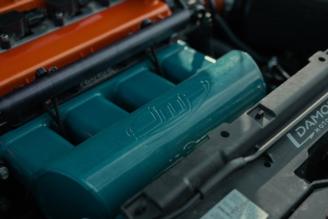 Turquoise JMF intake manifold beside the Damond port-injection hardware.